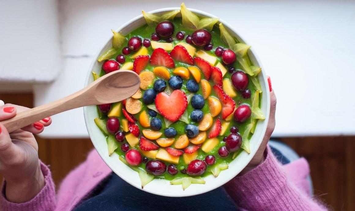 Detox cleanse smoothie served as a Green Bowl with lots of fruit toppings.
